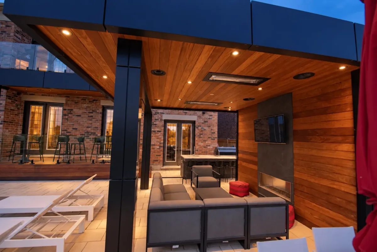 Warm downlights illuminate a wood-lined cabana lounge at dusk; lighting visualization based on a real project