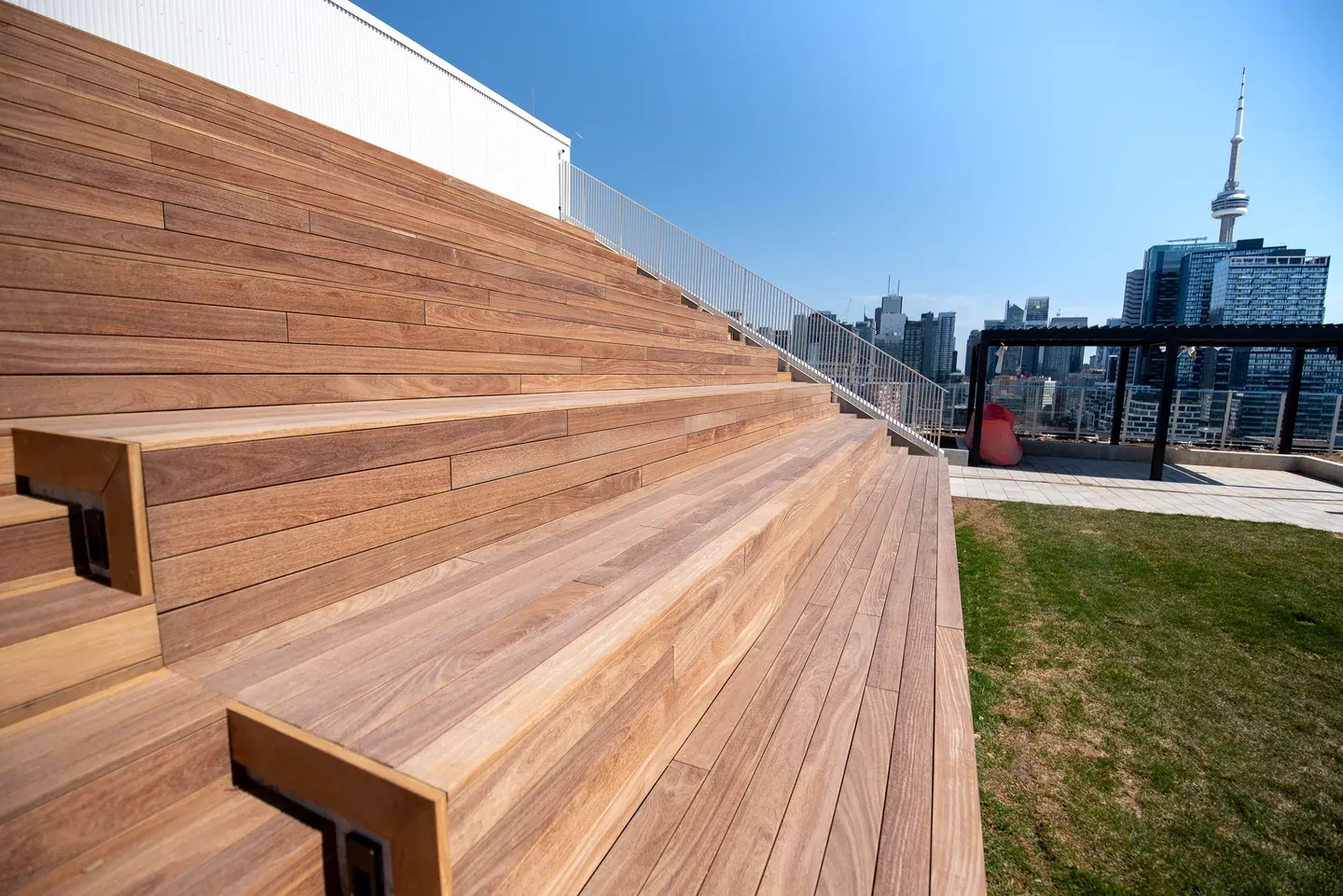 Close view of warm brown cumaru boards forming long tiers of outdoor rooftop seating.