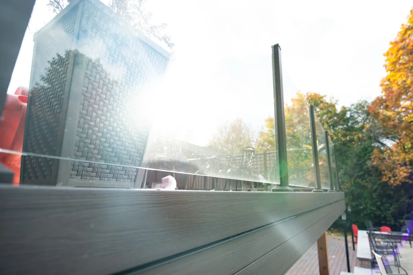 Close view of clear glass railing panels held between dark aluminum posts on a Toronto deck