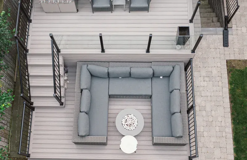 Backyard deck with a black aluminum picket guard running along its edge and down the stair flight.