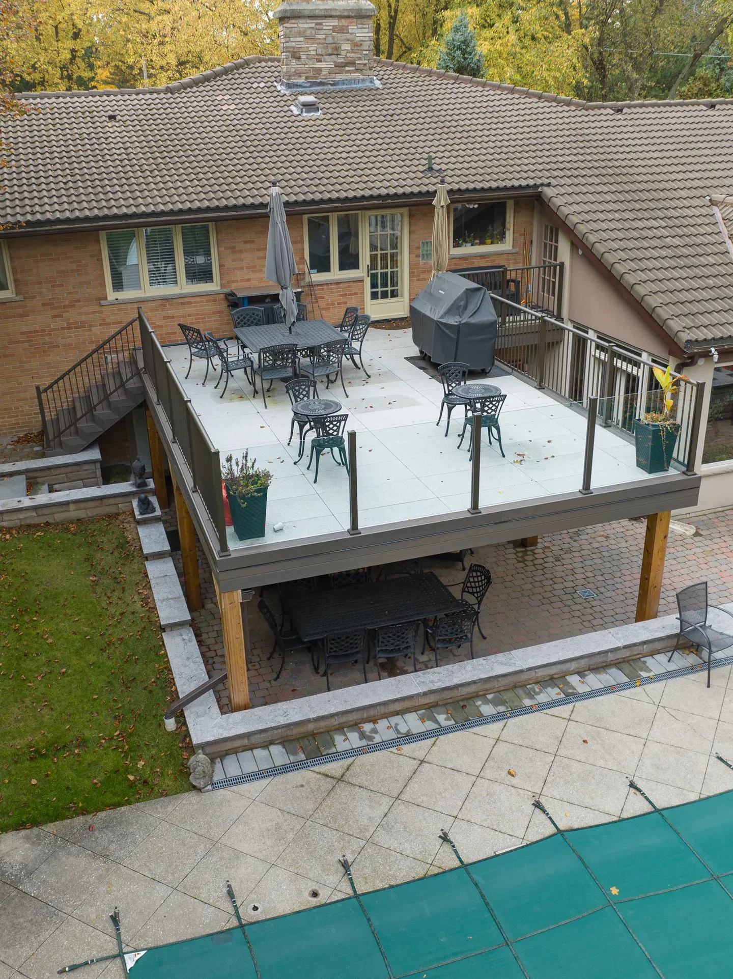Raised patio with glass panels along the front, picket side guards and a separate stair flight